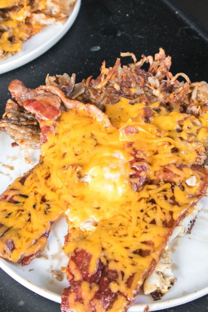 breakfast hashbrowns on a plate with eggs and cheese on top