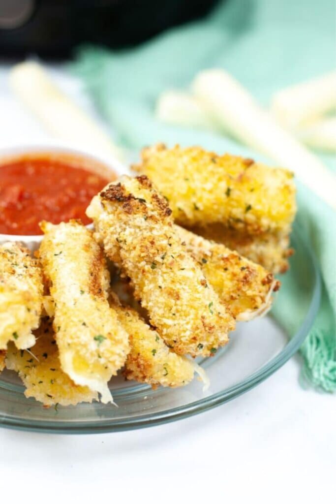plate of mozzarella sticks with marinara sauce in a bowl