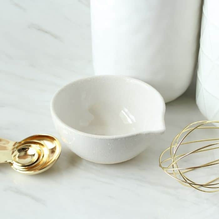 marble counter with measuring bowl, whisk and spoons by it