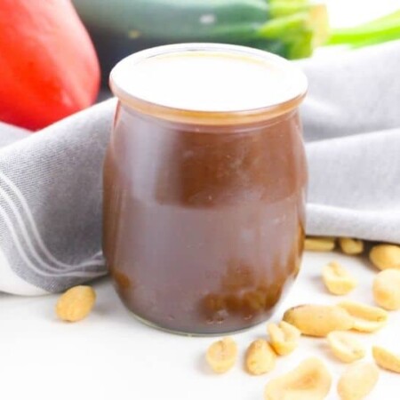 Kung Pao sauce in a jar with nuts around it