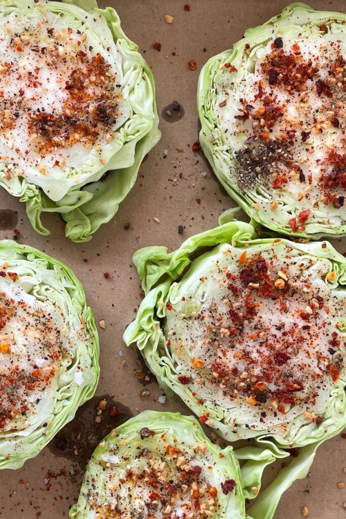 seasoned cabbage steaks on a baking sheet