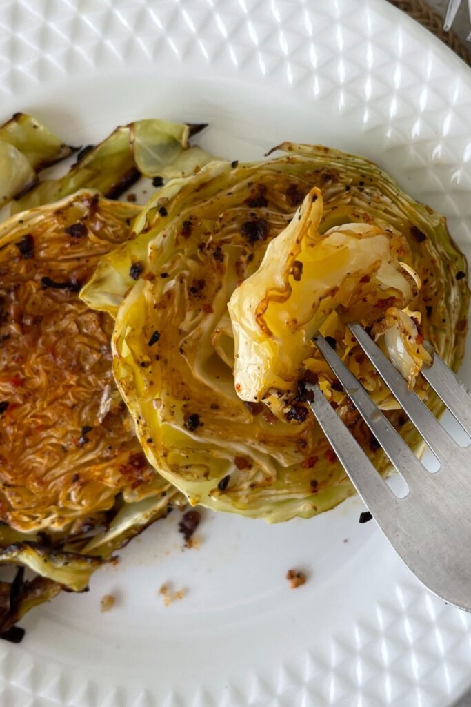 sliced cabbage on plate with fork of cabbage above