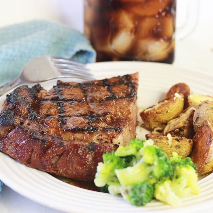 steak sliced in half on plate with fork and potatoes